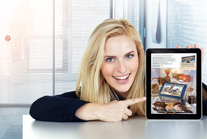 Frau zeigt mit Finger auf Tablet mit der Darstellung der Lebkuchen-Schmidt Webseite